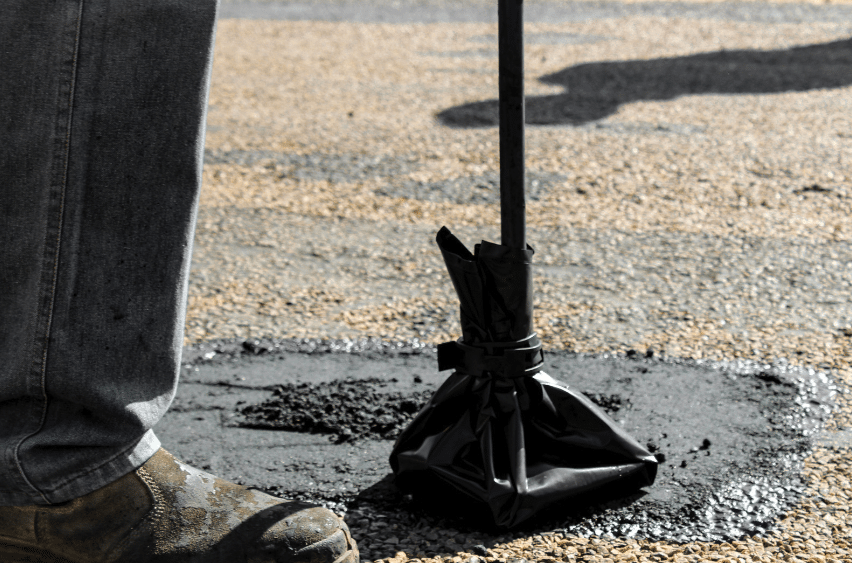 person patching and repairing asphalt surface